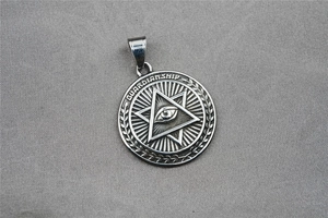 Détail macro du pendentif Guardian Eye argenté avec motif de blé et gravure vintage
