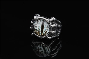 Macro view of gothic dragon claw ring with blue evil eye stone and metal scale textures