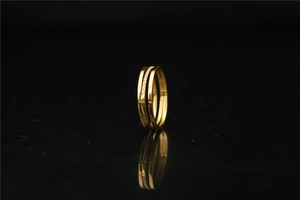 Nahaufnahme der goldenen dreilagigen Ringkombination mit Zirkonia auf schwarzem Hintergrund