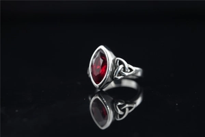 Détail macro de la bague nœud celtique vintage avec une grande pierre rouge marquise