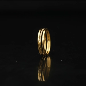 Dreilagiger Ring aus goldenem Titanstahl mit Kristallbesatz auf schwarzem Grund
