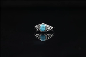 Macro detail of vintage titanium steel ring with turquoise stone and ethnic engraving