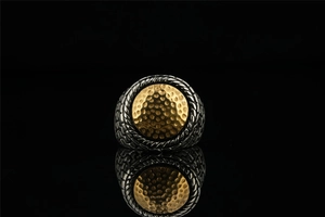 Macro shot of two-tone titanium steel ring with gold hammered texture and braided edges