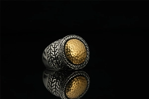 Detail of vintage steel ring with golden textured disc and geometric patterns
