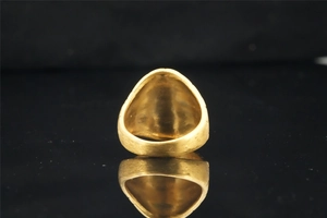 Macro shot of gold brushed titanium steel ring with unique punk texture and reflection