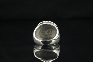 Macro shot of silver titanium steel ring with intricate vintage embossed floral patterns
