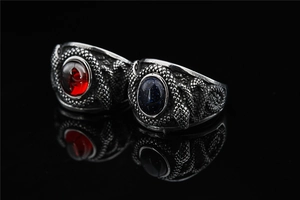 Détail de bagues punk serpent avec pierre rouge et pierre étoilée bleue en argent