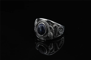 Vue macro d'une bague serpent en titane rétro avec incrustation ovale de pierre bleue étoilée