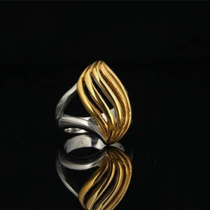 Two-tone wavy leaf ring in gold and silver stainless steel on black reflective surface