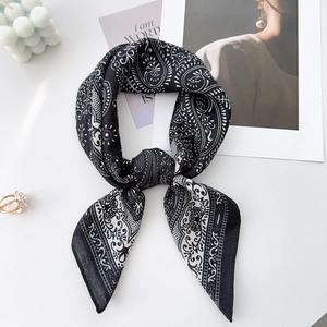 Detail of silk-satin paisley scarf with soft luster and elegant knotted texture
