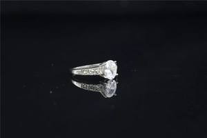 Detail of oval-cut moissanite engagement ring with side diamonds on silver band
