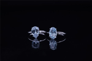 Close-up of teardrop and oval cut diamond rings in silver with four-prong settings