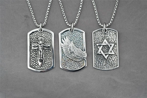 Detail of silver steel dog tag pendants with cross, angel wing, and star of david motifs