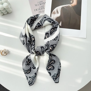 Detail of herringbone linen scarf with delicate black lace patterns and soft silk luster