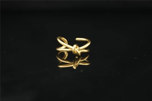 Vista macro dell'anello a nodo dorato lucido con elegante riflesso a specchio nero