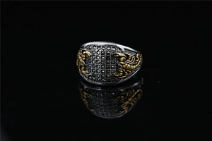 Détail de la bague en acier avec diamants noirs et relief de scorpion doré poli