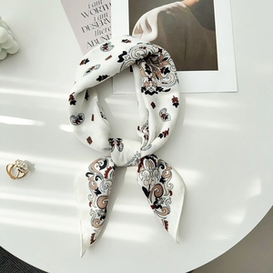 Détail macro d'un foulard en soie à motif cachemire avec ombre élégante sur fond épuré