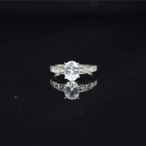 Classic silver moissanite ring with oval center stone and side accents on black background