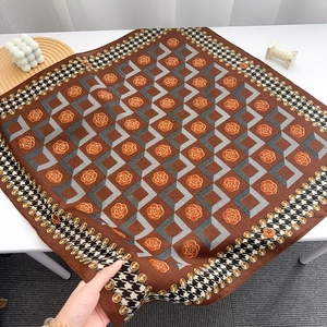 Detail of vintage brown silk scarf showing floral patterns and houndstooth border