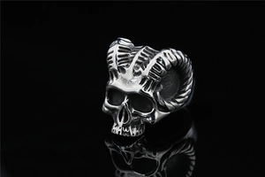 Macro view of vintage stainless steel skull ring with detailed ram horns and aged finish