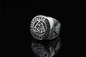 Macro shot of silver Valknut ring with Norse runes and vintage industrial finish