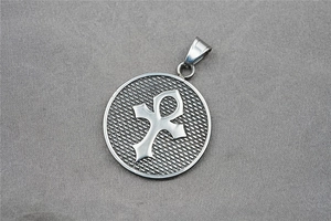 Macro shot of silver titanium steel round pendant with embossed Ankh cross symbol and texture