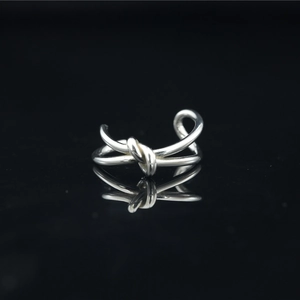 Anello a nodo in acciaio inossidabile argento lucido con riflesso elegante su nero