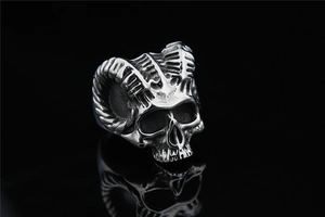 Macro detail of gothic skull ring with large spiral horns in retro stainless steel
