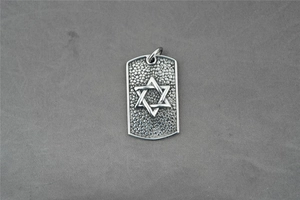 Macro view of a rectangular titanium steel pendant featuring a Star of David and textured base