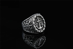 Detailed view of vintage silver steel ring featuring anchor and helm nautical carvings