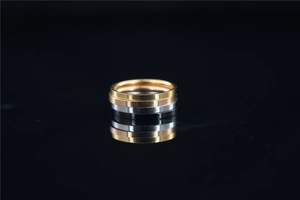 Macro shot of minimalist four-color titanium steel rings stacked on a black mirror base