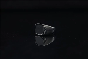 Vue macro de la bague de sceau pour hommes avec pierre noire et reflet métallique poli