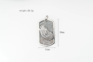 Detailed macro view of square metal pendant with embossed feather wing design and size info