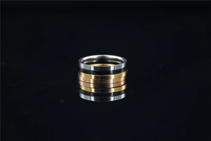 Detail of five stackable titanium steel rings in gold, silver, black, and rose gold finish