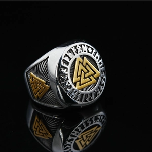 Silver and gold Viking Valknut ring with engraved runes on a mirrored surface