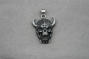 Macro shot of Viking bull horn skull pendant with gothic details on a grey background