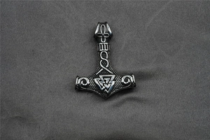 Macro shot of Viking Mjolnir pendant featuring Valknut symbol and antique steel finish