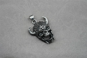 Detailed view of vintage bull horn skull pendant with gothic helmet and hollow cross