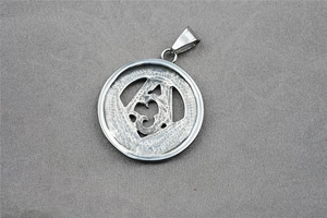 Détail d'un pendentif maçonnique en acier inoxydable argenté avec texture martelée