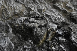 Macro view of vintage braided steel bangle featuring detailed Viking wolf head finials