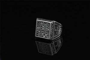 Detailed view of punk square ring with black stones and engraved crown motif
