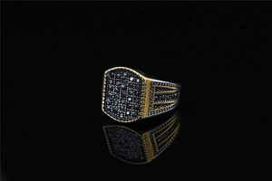 Makroaufnahme von Herrenring aus Titan mit schwarzen Zirkonia und goldenem Relief
