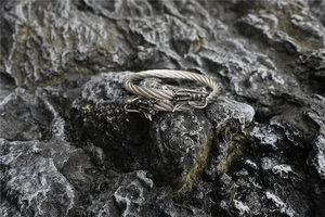Detail shot of vintage stainless steel twin dragon head bracelet with twisted cable design