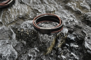 Detail of multi-layer leather cord bracelet with matte black magnetic stainless steel buckle