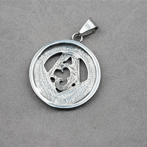 Pendentif médaillon franc-maçon en acier inoxydable argenté poli sur fond de tissu gris