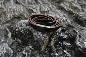 Detail of multilayer leather bracelet with black magnetic clasp on a natural grey rock