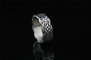 Macro detail of vintage silver viking ring with intricate celtic knot weaving patterns