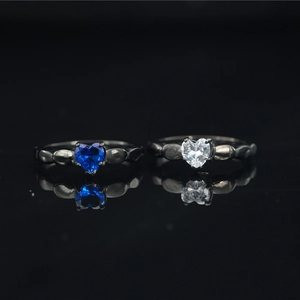 Elegante par de anillos de moissanita con corazón, acabado negro y piedras azul y blanca