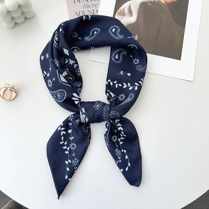Detail of navy blue paisley print scarf knotted in a French vintage aesthetic style