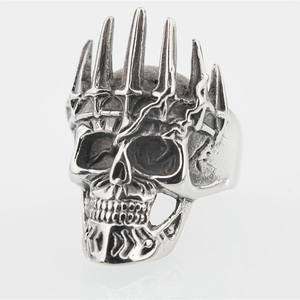 Bague gothique punk tête de mort argentée avec couronne à pointes sur fond blanc
